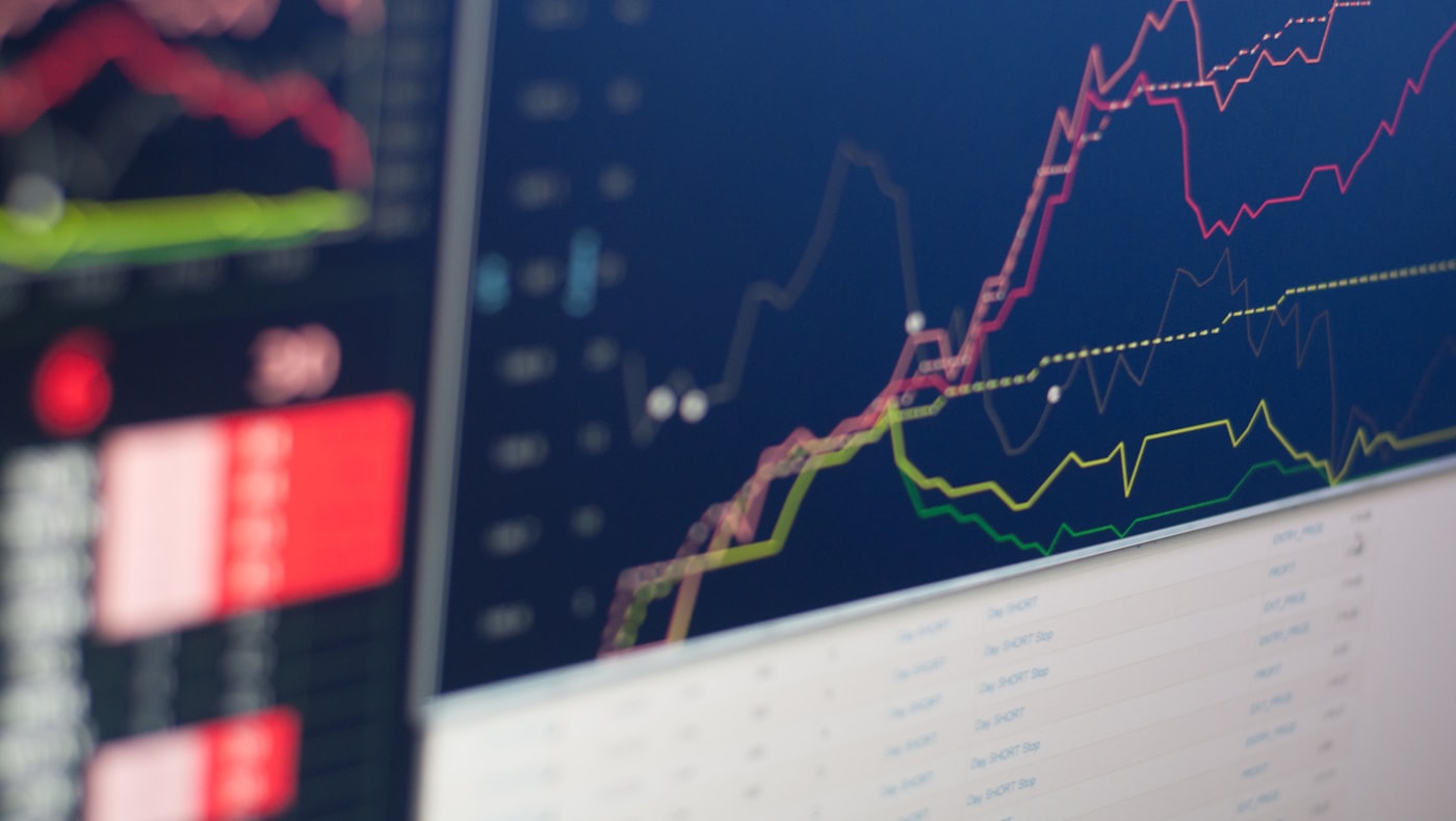 Des graphiques en courbes colorés sur des écrans de trading