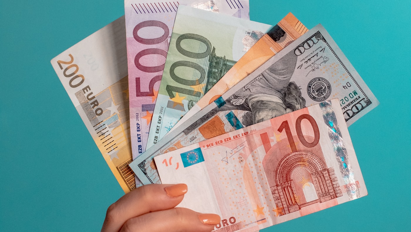 Une main tenant un éventail de billets de banque en papier